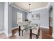Modern dining room with a glass table, unique lighting, and hardwood floors at 5170 Black Bear Trl, Douglasville, GA 30135
