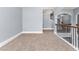 Neutral hallway with carpet flooring, white trim, and wrought iron railing at 5170 Black Bear Trl, Douglasville, GA 30135