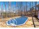 Beautiful in-ground pool surrounded by a wooden deck and mature trees at 5170 Black Bear Trl, Douglasville, GA 30135