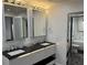 Stylish bathroom featuring double sinks, modern lighting, and a glass shower door at 361 17Th Nw St # 2423, Atlanta, GA 30363