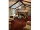 Living room area with outdated carpet, a fireplace, and wood beam ceilings at 5581 Shadow Rock Dr, Lithonia, GA 30058