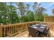 Outdoor deck with a dining table surrounded by mature trees providing shade and privacy at 1741 Lansmere Sw St, Marietta, GA 30008