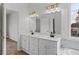 A bathroom with a double sink vanity, marble accents, and views to a deck via the window at 1471 Adair Hill Ct, Dacula, GA 30019
