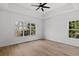 Spacious bedroom features tray ceilings, a ceiling fan, and large windows offering natural light and views of the surrounding greenery at 1471 Adair Hill Ct, Dacula, GA 30019