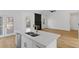 Bright kitchen island with stainless steel appliances and an open floor plan to a living area with a black fireplace at 1471 Adair Hill Ct, Dacula, GA 30019