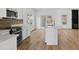 Kitchen featuring an island, modern appliances, white cabinetry, decorative backsplash, and open floorplan at 1471 Adair Hill Ct, Dacula, GA 30019