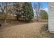 Fenced backyard with a mix of grass and mulched areas, with mature trees at 939 Mill Creek Ave, Canton, GA 30115