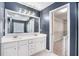 Bathroom featuring a double sink vanity, a walk-in closet, and neutral walls at 939 Mill Creek Ave, Canton, GA 30115