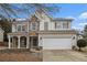 Home featuring neutral siding, stone accents, well-kept lawn, and a convenient two-car garage at 939 Mill Creek Ave, Canton, GA 30115