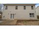 Rear exterior of home with tan siding, windows, and a walkout basement door at 939 Mill Creek Ave, Canton, GA 30115
