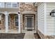 Detailed view of a home's stone-accented entrance featuring a stylish front door and complementary exterior lighting at 939 Mill Creek Ave, Canton, GA 30115