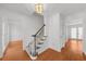 Bright foyer showcasing hardwood floors, staircase with light wood railing, and stylish light fixture at 1655 Pine Ridge Cir, Woodstock, GA 30188