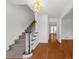 Bright foyer showcasing hardwood floors, staircase with dark wood railing, and stylish light fixture at 1655 Pine Ridge Cir, Woodstock, GA 30188