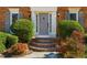 Close-up of the front entrance with brick steps, decorative shrubbery, and elegant wall-mounted lanterns at 1655 Pine Ridge Cir, Woodstock, GA 30188