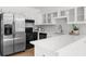 Bright kitchen features stainless steel refrigerator, granite counters, tile backsplash, and white cabinets at 1655 Pine Ridge Cir, Woodstock, GA 30188