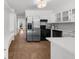 Charming kitchen features stainless steel refrigerator, modern appliances, white cabinets and tile flooring at 1655 Pine Ridge Cir, Woodstock, GA 30188