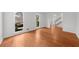 Open-concept living room with hardwood floors, large windows, and a glimpse of the staircase in the foyer at 1655 Pine Ridge Cir, Woodstock, GA 30188