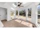 Bright sunroom with vaulted ceiling, ceiling fan, tiled floors and large windows overlooking the backyard at 1655 Pine Ridge Cir, Woodstock, GA 30188