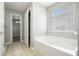 Bathroom featuring a jacuzzi tub, tile flooring, and walk-in closet at 3272 Tiara Sw Cir, Atlanta, GA 30311