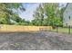 Large, flat backyard featuring new wood fence and black metal fence, surrounded by mature trees at 5447 Blossomwood Sw Trl, Mableton, GA 30126