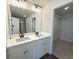 Bathroom with double vanity, large mirror, modern lighting, and walk-in closet at 5447 Blossomwood Sw Trl, Mableton, GA 30126
