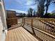 View of a wood deck with wood railing overlooking a parking lot with trees in the background on a sunny day at 5447 Blossomwood Sw Trl, Mableton, GA 30126