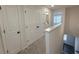 Hallway with carpet and multiple doors, including one leading to a bathroom and one that is a closet at 5447 Blossomwood Sw Trl, Mableton, GA 30126