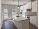 Stylish kitchen featuring white cabinets, stainless steel appliances, and an island with a sink and quartz countertop at 5447 Blossomwood Sw Trl, Mableton, GA 30126