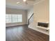 Inviting living area with modern fireplace, a large window with views, and dark laminate flooring at 5447 Blossomwood Sw Trl, Mableton, GA 30126