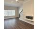 Bright living room with hardwood floors, large window, modern fireplace, and staircase at 5447 Blossomwood Sw Trl, Mableton, GA 30126