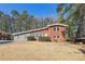 Beautifully updated brick house with a lush green lawn and mature trees offering shade at 3035 Mclendon Nw Cir, Atlanta, GA 30318