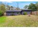 Exterior view of backyard with a well-maintained lawn and dark gray siding under blue skies at 3280 Hazelwood Sw Dr, Atlanta, GA 30311