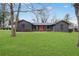 Charming single-story home with dark brick exterior, orange front door and a lush green lawn at 3280 Hazelwood Sw Dr, Atlanta, GA 30311
