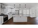 Modern kitchen with white cabinets, stainless steel appliances, an island with barstool seating, and wood floors at 3280 Hazelwood Sw Dr, Atlanta, GA 30311