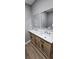 A modern bathroom with a double sink vanity, marble countertop, and wood-look cabinetry at 3814 Rex Rd, Rex, GA 30273