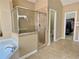 Bathroom featuring a glass-enclosed shower, soaking tub and entrance to the walk-in closet at 5066 Healey Dr, Smyrna, GA 30082