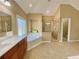 Bright bathroom featuring a large soaking tub, glass-enclosed shower, and double vanity with solid surface counter at 5066 Healey Dr, Smyrna, GA 30082
