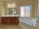 Bright main bathroom showcasing a jacuzzi tub, wood cabinetry, and natural light at 5066 Healey Dr, Smyrna, GA 30082