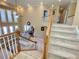 Elegant staircase leading to the upper level, overlooking a spacious living room with soaring windows and fireplace at 5066 Healey Dr, Smyrna, GA 30082