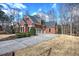 Beautiful brick home showcasing a well-manicured lawn, mature trees, and an extended driveway leading to a two-car garage at 2139 Golden Morning Ct, Kennesaw, GA 30152