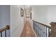 A hallway with hardwood floors and a view of framed art pieces on the wall at 2139 Golden Morning Ct, Kennesaw, GA 30152