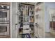 Organized pantry shelves with wire baskets for maximum storage capacity next to double ovens at 2139 Golden Morning Ct, Kennesaw, GA 30152