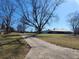 Long driveway leading to a house and an outbuilding, bordered by grassy lawns and mature trees at 46 Mac Johnson Nw Rd, Cartersville, GA 30121