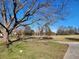 Spacious lawn with mature trees casting shadows, sidewalk, and a glimpse of houses in the background at 46 Mac Johnson Nw Rd, Cartersville, GA 30121