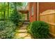 Brick home exterior featuring stone pathway, lush landscaping and mature trees at 730 Jackson Miller Cir, Powder Springs, GA 30127