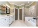 Bright bathroom featuring a soaking tub, glass-enclosed shower, and a double vanity at 730 Jackson Miller Cir, Powder Springs, GA 30127