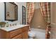 Charming bathroom featuring a vanity, framed mirror, toilet and shower with colorful curtain at 730 Jackson Miller Cir, Powder Springs, GA 30127