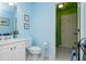 This is a light blue bathroom with a toilet, white sink vanity and an open door to the shower at 730 Jackson Miller Cir, Powder Springs, GA 30127