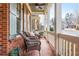 Charming front porch features brick flooring, wicker seating, and classic white columns for a welcoming exterior at 730 Jackson Miller Cir, Powder Springs, GA 30127