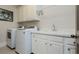 Functional laundry room with white appliances, sink, and ample counter space for folding at 730 Jackson Miller Cir, Powder Springs, GA 30127